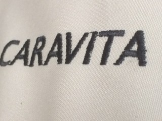 Macro detail of a brand wordmark embroidered into canopy fabric, close stitch work