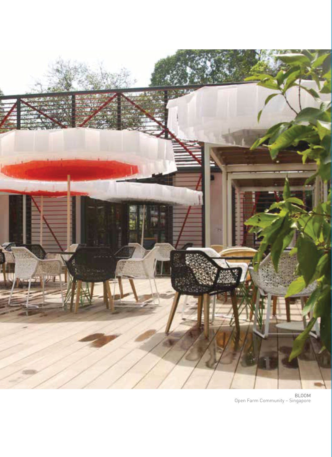 Pleated white parasol canopies, one with a red underside, over a raised deck restaurant